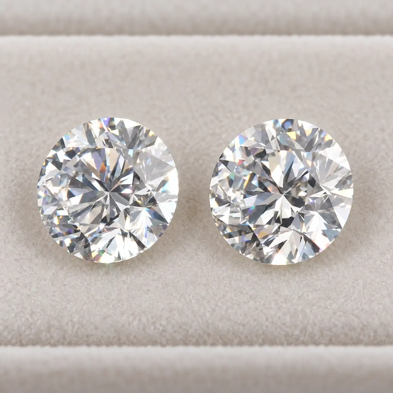 Two loose round lab-grown diamonds viewed side by side.
