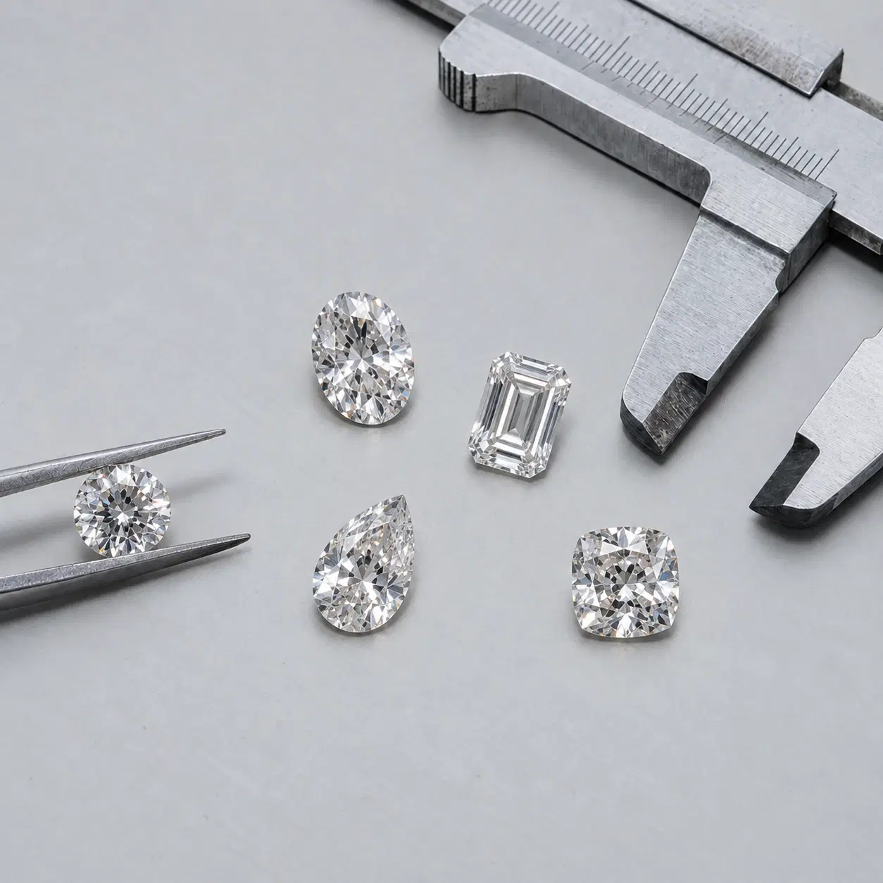Loose diamonds beside a measuring instrument.